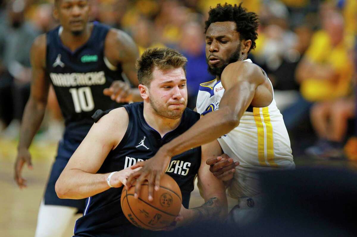 Golden State Warriors forward Andrew Wiggins (22) defends Dallas Mavericks guard Luka Doncic (77) during the second quarter in Game 2 of the Western Conference finals at Chase Center, Friday, May 20, 2022, in San Francisco, Calif. Payton II is out due to injury.