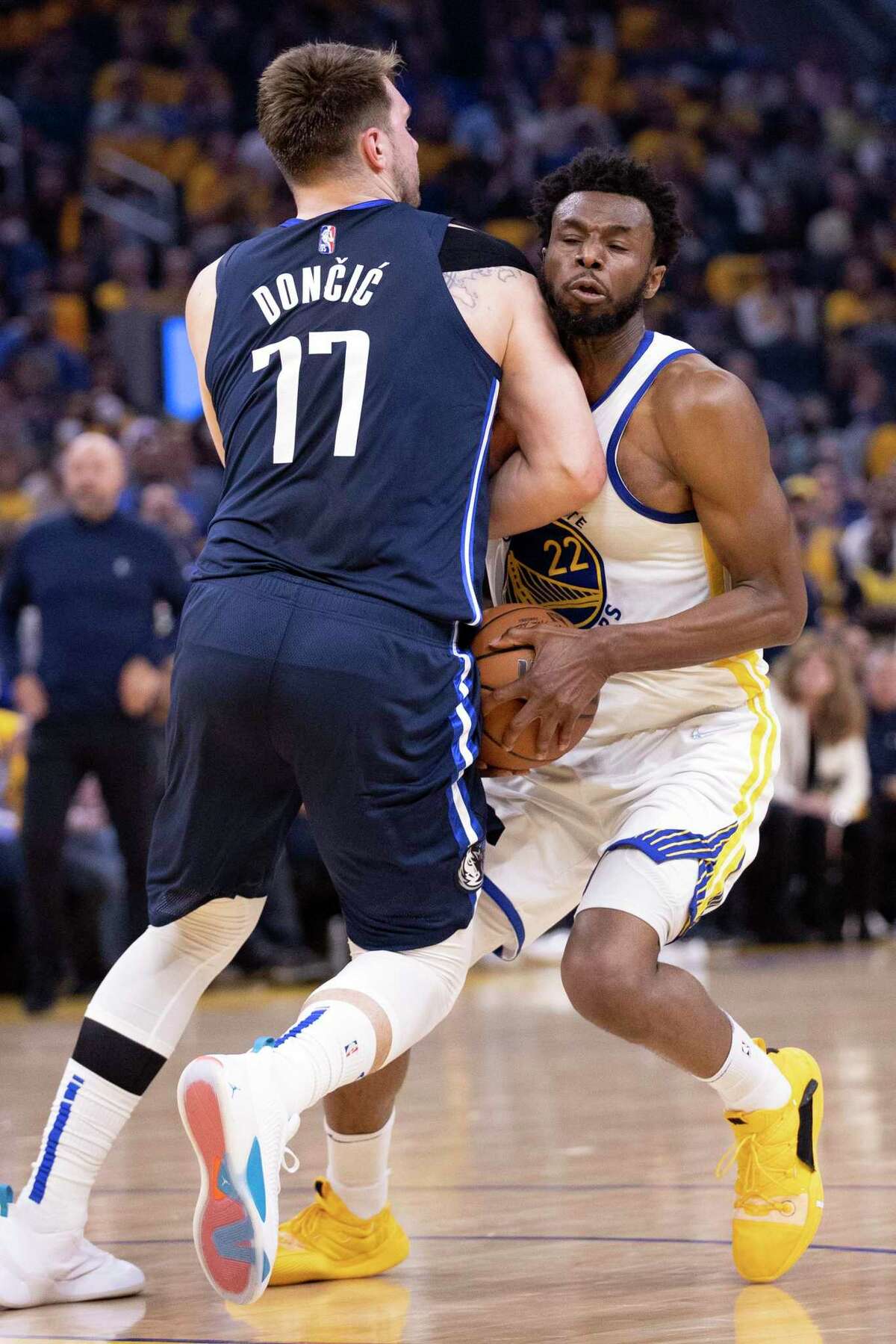 Dallas Mavericks’ Luka Doncic puts his shoulder into Golden State Warriors’ Andrew Wiggins during 1st quarter of Game 2 of NBA Western Conference Finals at Chase Center in San Francisco, Calif., on Friday, May 20, 2022. Wiggins score don the play but no foul was called.