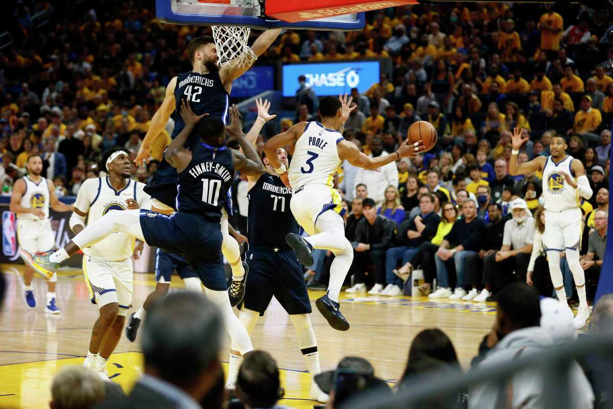 Golden State Warriors guard Jordan Poole (3) draws the Dallas Mavericks and makes the pass in the fourth quarter in Game 2 of the Western Conference finals at Chase Center, Friday, May 20, 2022, in San Francisco, Calif.
