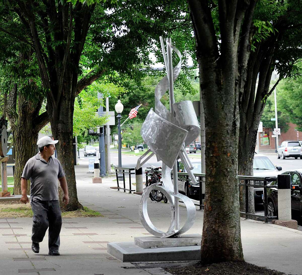 A passerby looks at "Ode to Growth," a sculpture piece by artist Glenn Zweygardt, Thursday, June 29, 2017. The art is part ofv a "sculpture garden" on Main Street in Danbury. Leaders have suggested Danbury created a department focused on the arts and culture.