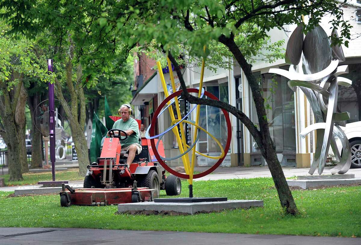 Bob Dangaard, an employee of the Danbury Parks and Recreation Department, cuts the grass around the sculpture garden on Main Street in Danbury, Thursday, June 29, 2017. Leaders have suggested Danbury created a department focused on the arts and culture.