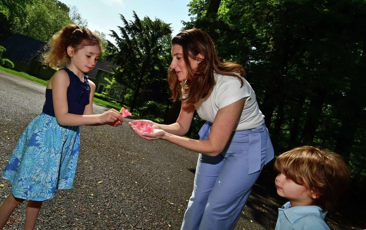 Calista Mecsery, left, hands her mom Cassie in front of their home in Darien, Conn., on Saturday May 21, 2022. At right is Cassie's son Westley Stephen. Cassie's husband Sean died recently after a two-year battle with an aggressive form of brain cancer. Sean, who was a Darien native, was the owner of Greenwich-based Cos Cob TV and Audio. Cassie is continuing to run the store, which first opened in 1945.