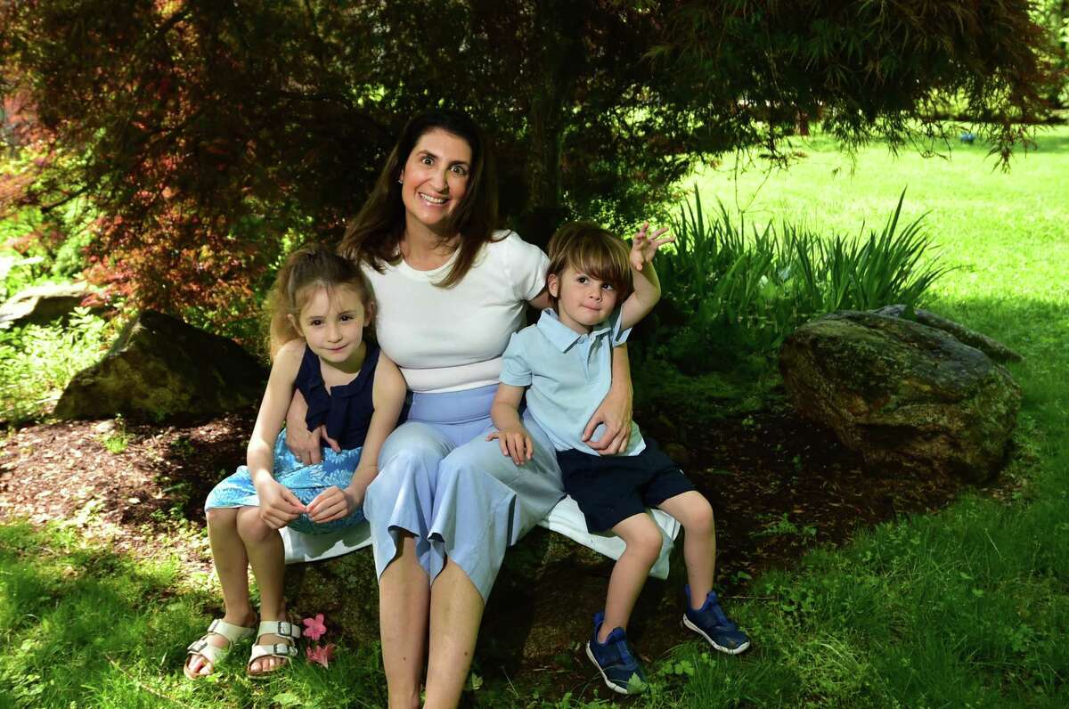 Cassie Mecsery poses with her children Calista and Westley Stephen at their home in Darien, Conn., on Saturday May 21, 2022. Cassie's husband Sean died recently after a two-year battle with an aggressive form of brain cancer. Sean, who was a Darien native, was the owner of Greenwich-based Cos Cob TV and Audio. Cassie is continuing to run the store, which first opened in 1945.