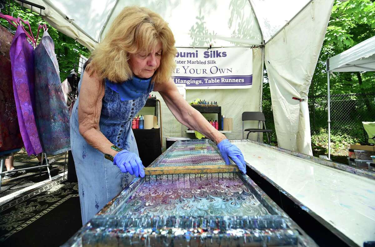 Patricia DeSantis, with Shibumisilks, prepares solution to die a silk scarf during Bruce Museum's 37th Annual Crafts Festival in Greenwich, Conn., on Saturday May 21, 2022. Artisans from all over New England and the East Coast will travel to the Bruce Museum, bringing with them fine contemporary hand-made crafts in jewelry, wearable and decorative fiber, glass, furniture, housewares, pottery, and much more.