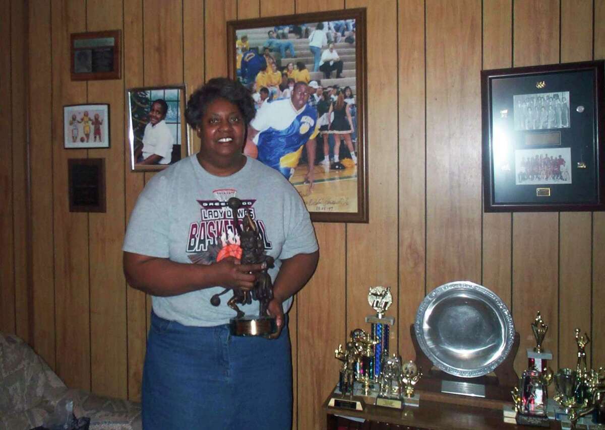 Lusia Harris Stewart shows off some of her medals and awards from her basketball career, Jan. 10, 2002, in her home in Greenwood, Miss. Harris, who was the only woman to be drafted by an NBA team and scored the first points in women's basketball history at the Olympics, died Tuesday, Jan. 18, 2022, her family announced. She was 66.