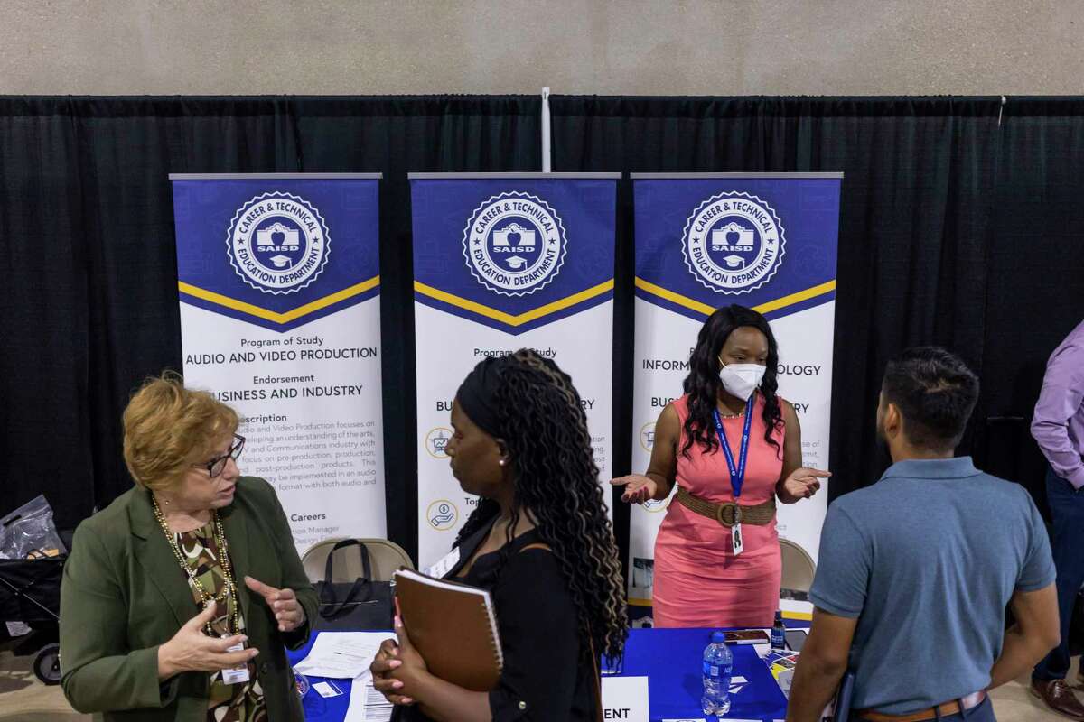 Konise Millender, right, the district’s career and technical education coordinator, talks with a potential job candidate during Saturday’s job fair.