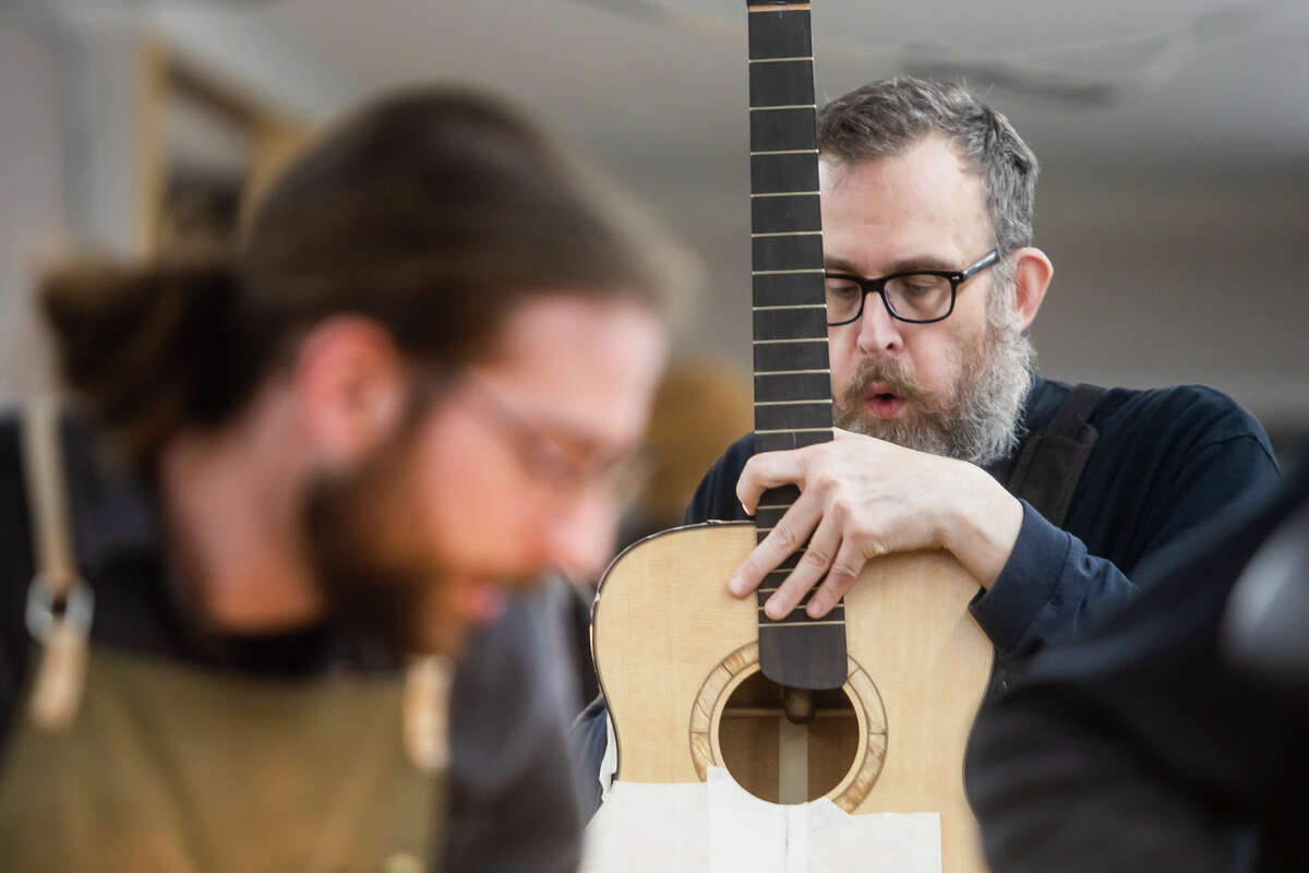 Andrew Lord of Washington works on his guitar at the Galloup School of Guitar Building and Repair Tuesday, April 19, 2022 in Big Rapids.