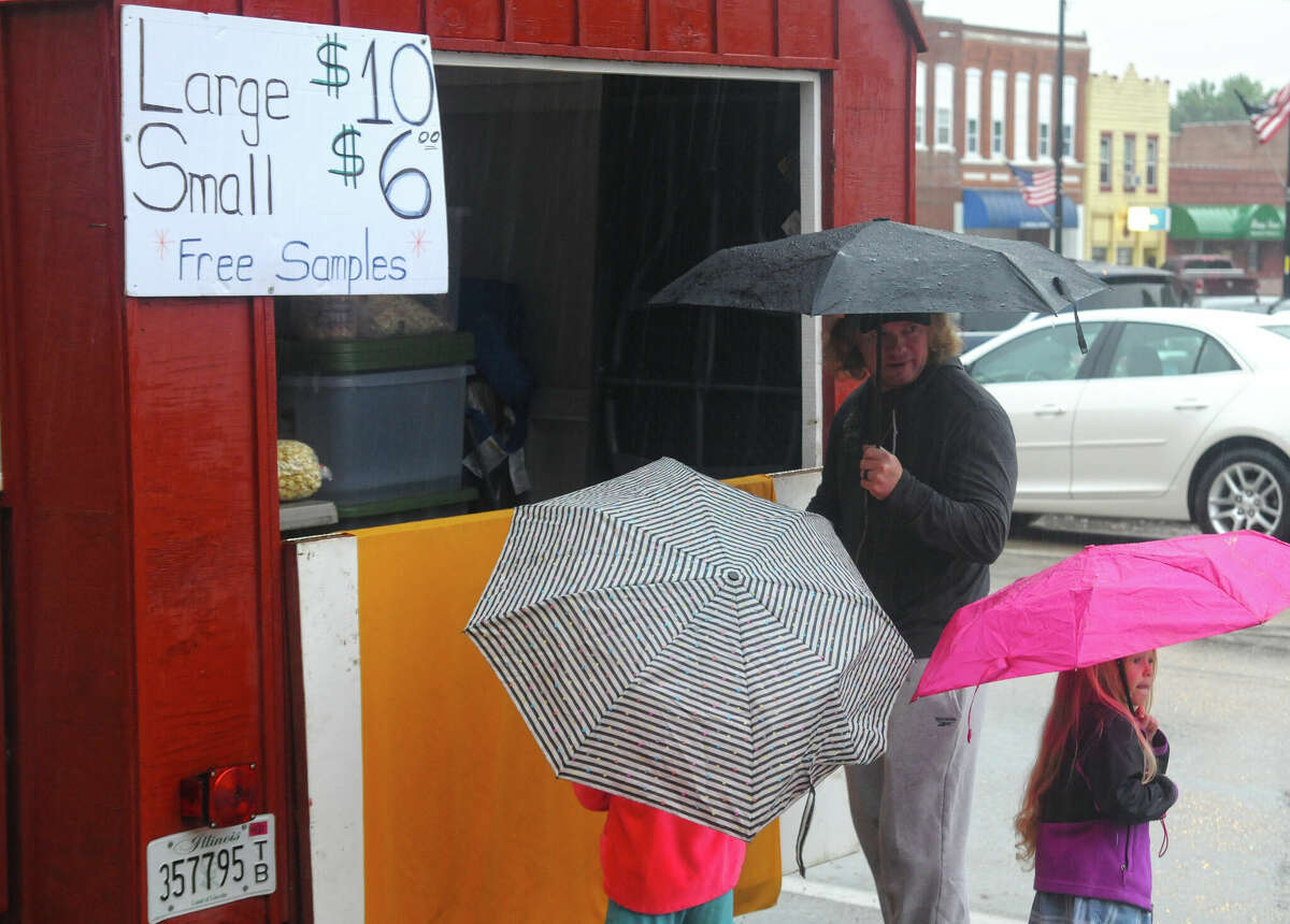Caramel corn proves too hard to resist as a family braves the heavy rain at the Artisans Market in Carrollton.