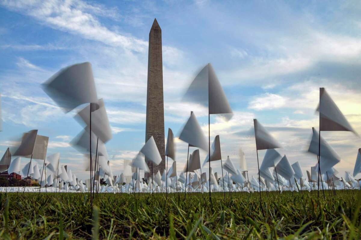 FILE: An installation on Sept. 15, 2021 blankets the National Mall in Washington with more than 660,000 white flags, honoring lives lost to the coronavirus in the United States up to that time. As the United States reaches 1 million known deaths, there is no national, permanent memorial to the country?•s loss. Some survivors have called for more to be done. (Kenny Holston/The New York Times))