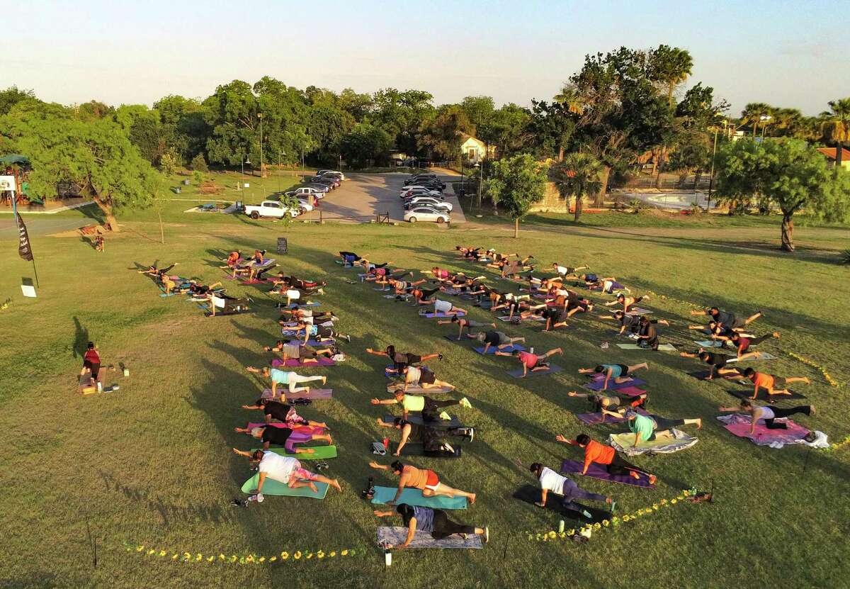 People in a yoga exercise class led by Stacie Orsagh work out at Woodlawn Lake on Wednesday, May 11, 2022.