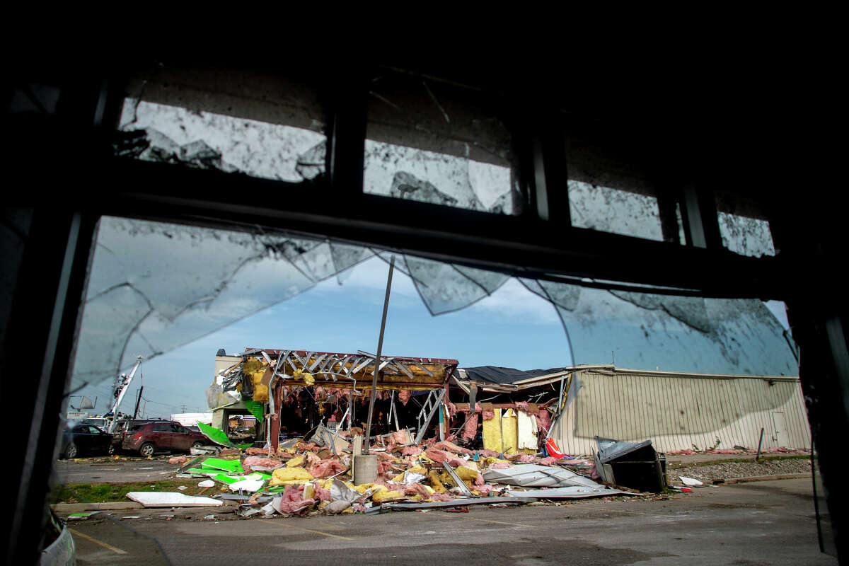 The remains of the Goodwill building are seen through the shattered window at Little Caesers, Saturday, May 21, 2022, after a tornado came through the area by Michigan state Highway 32 the day before, in Gaylord, Mich. (Jake May/MLive.com/The Flint Journal via AP)