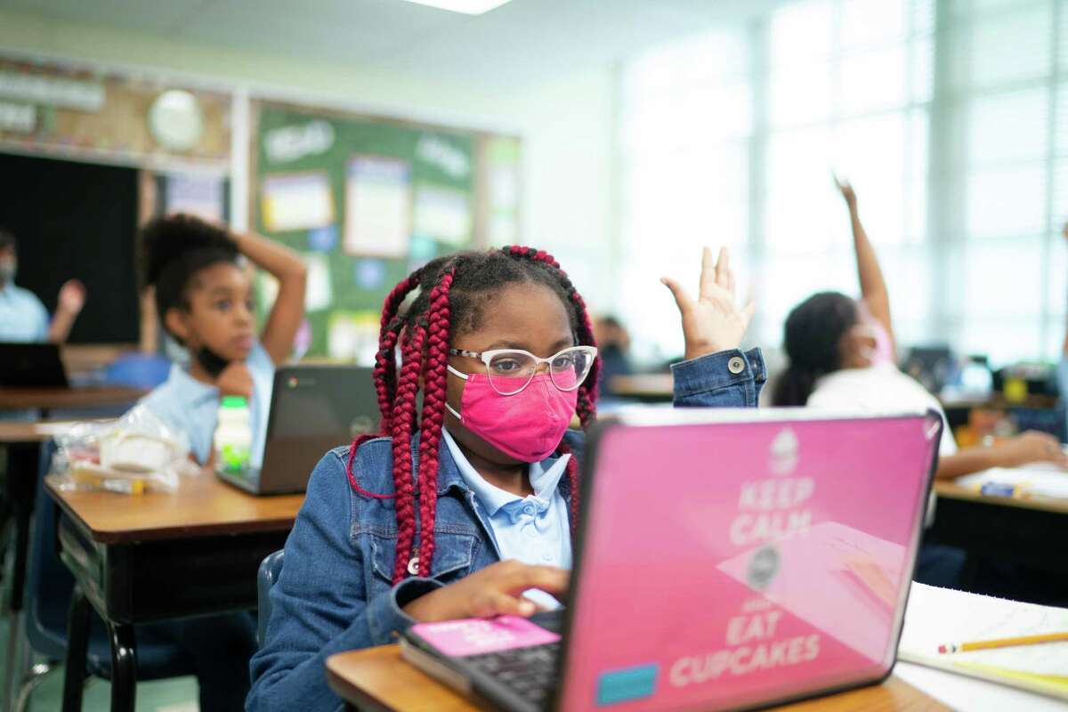 Capitol Heights Elementary School fourth grader Averie Timberlake raises her hand in a class that is also being attended by virtual students in October 2021. (