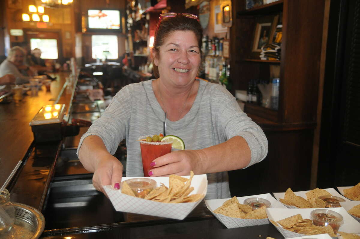 Bloody Bucket employee Cheryl Thompson prepares to serve chips, salsa and a Bloody Mary during Grafton's Sip, Sample and Stroll on Saturday.