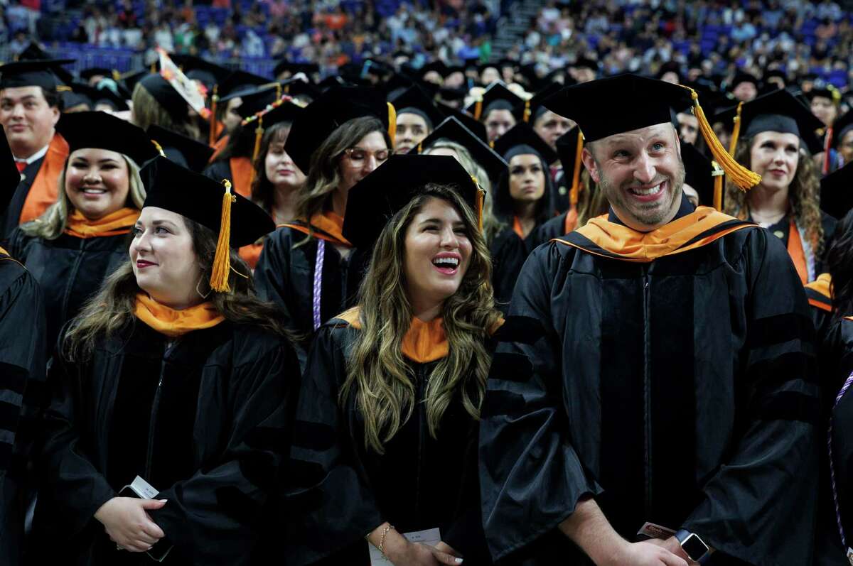 Doctor of nursing practice graduates Allysa Garcia, from left, Sarah Grimmer, Jeffrey Joseph Hadac and others listen to cheers from the crowd at UT Health San Antonio’s commencement Saturday at the Alamodome.