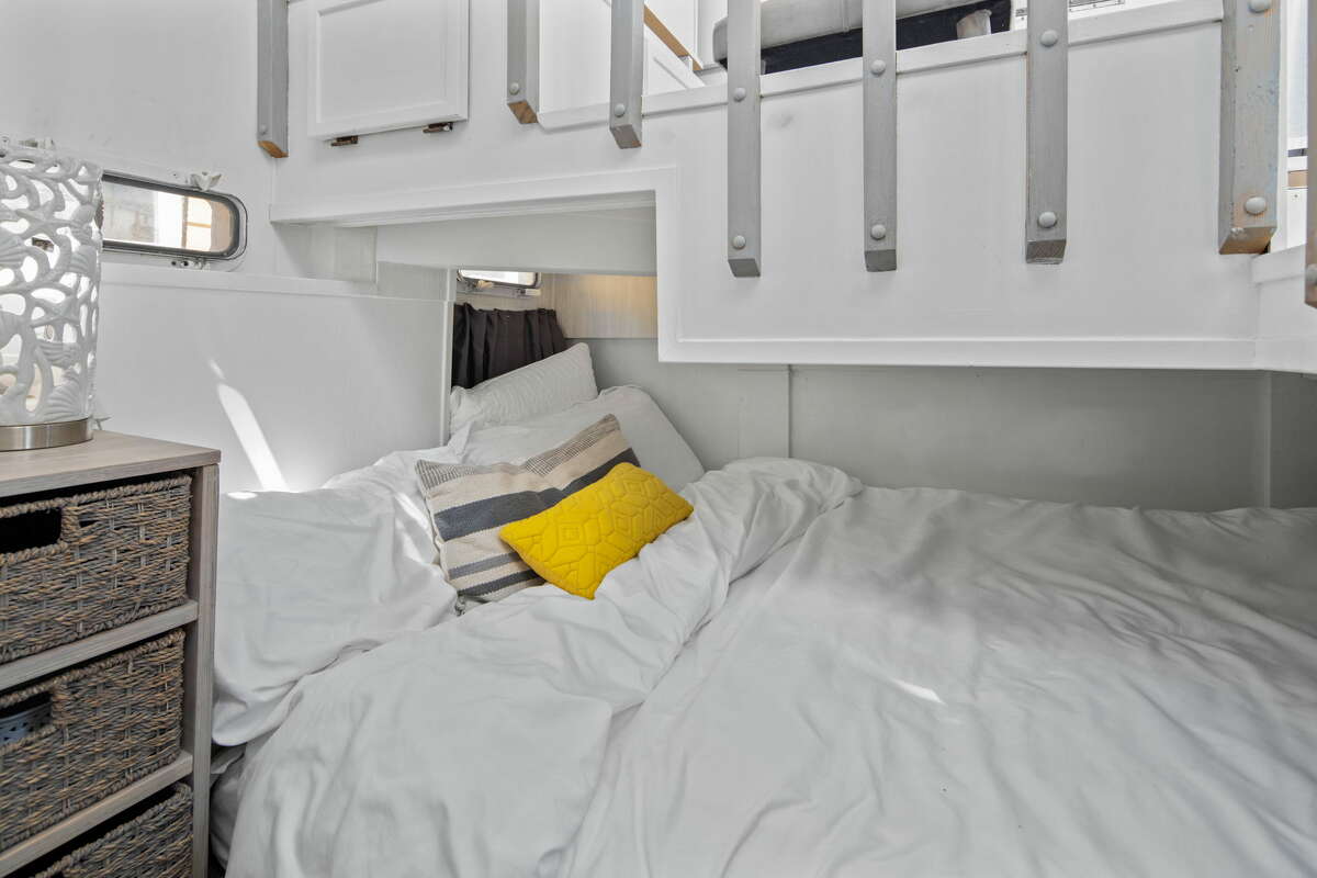 The bedroom, nestled under a staircase, is cozy.
