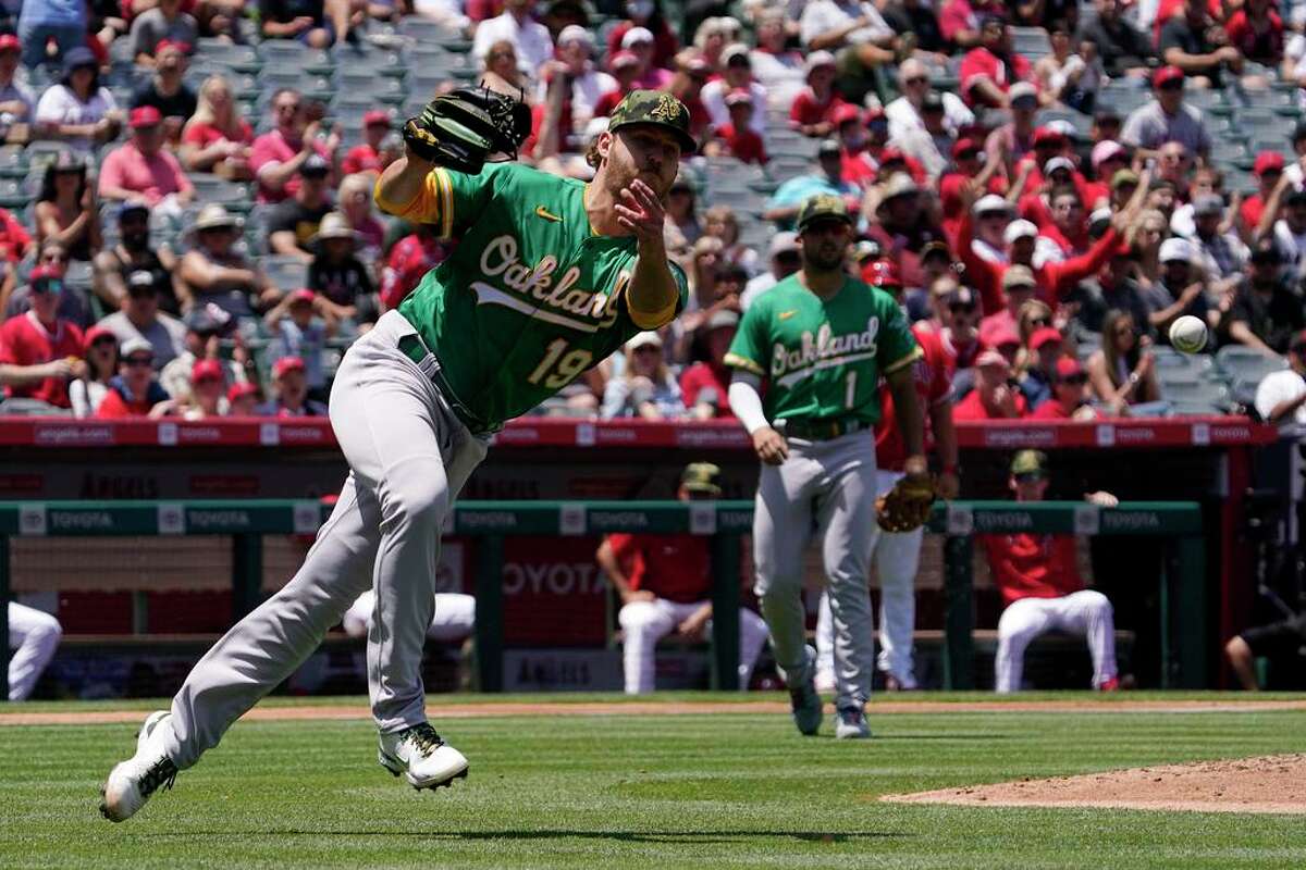 Oakland Athletics starting pitcher Cole Irvin attempts to throw out Los Angeles Angels' Tyler Wade at first during the second inning of a baseball game Sunday, May 22, 2022, in Anaheim, Calif. Wade was safe at first on the play. (AP Photo/Mark J. Terrill)