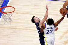 Andrew Wiggins of the Golden State Warriors dunks the ball against Luka Doncic of the Dallas Mavericks during the fourth quarter in Game Three of the 2022 NBA Playoffs Western Conference Finals May 22, 2022.
