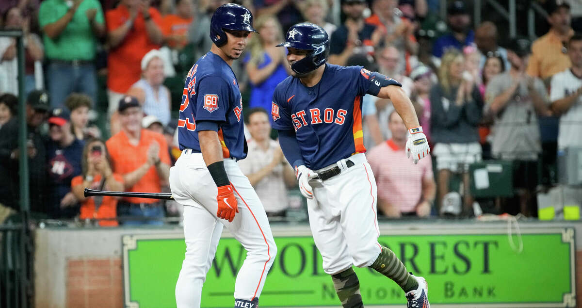 Houston Astros second baseman Jose Altuve (27) celebrates with designated hitter Michael Brantley (23) after he hit a home run during the first inning of an MLB game Sunday, May 22, 2022, at Minute Maid Park in Houston.
