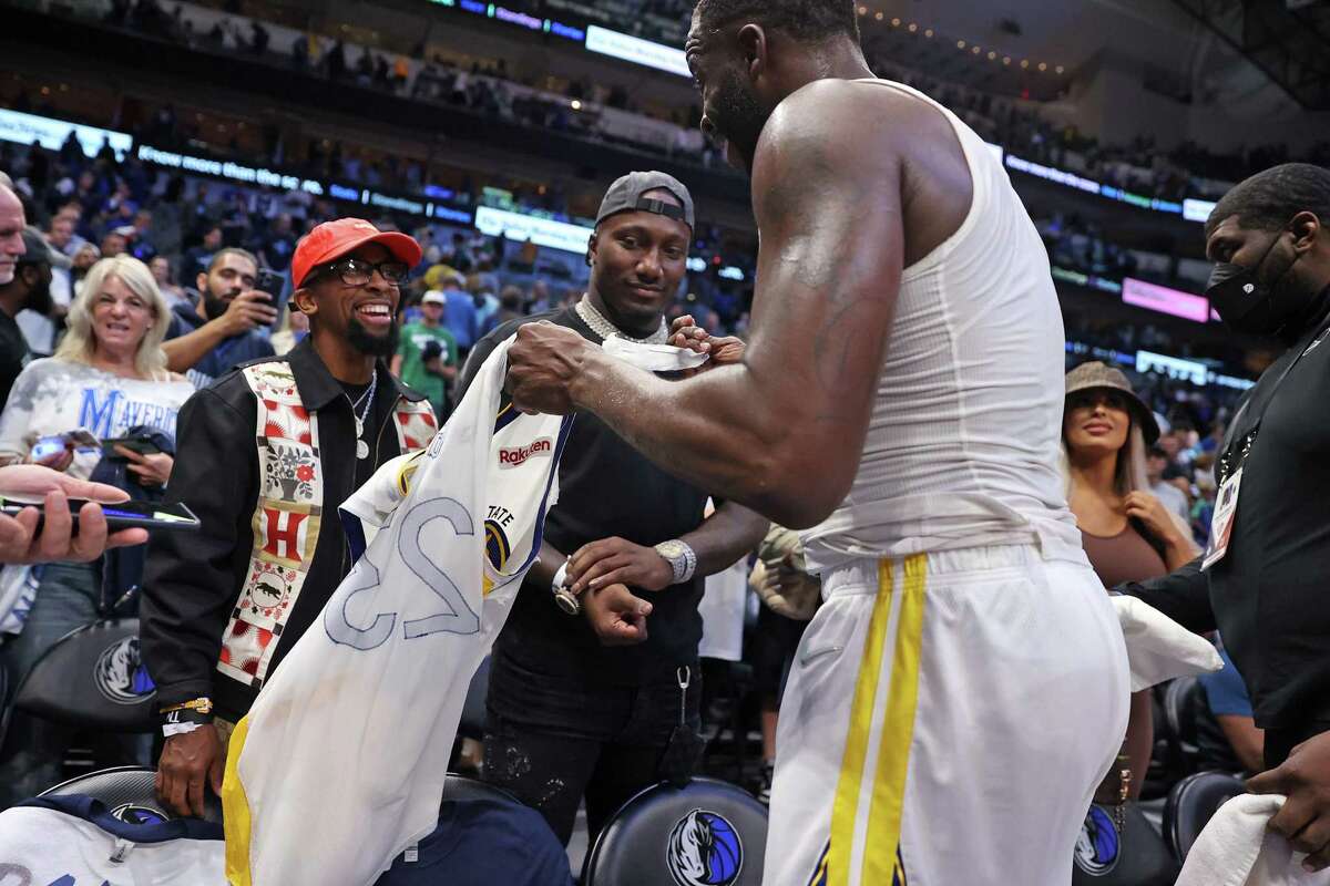 Golden State Warriors’ Draymond Green gives part of his jersey to Deebo Samuel after Warriors’ 109-100 win over Dallas Mavericks in Game 3 of NBA Western Conference Finals at American Airlines Center in Dallas, Texas, on Sunday, May 22, 2022.