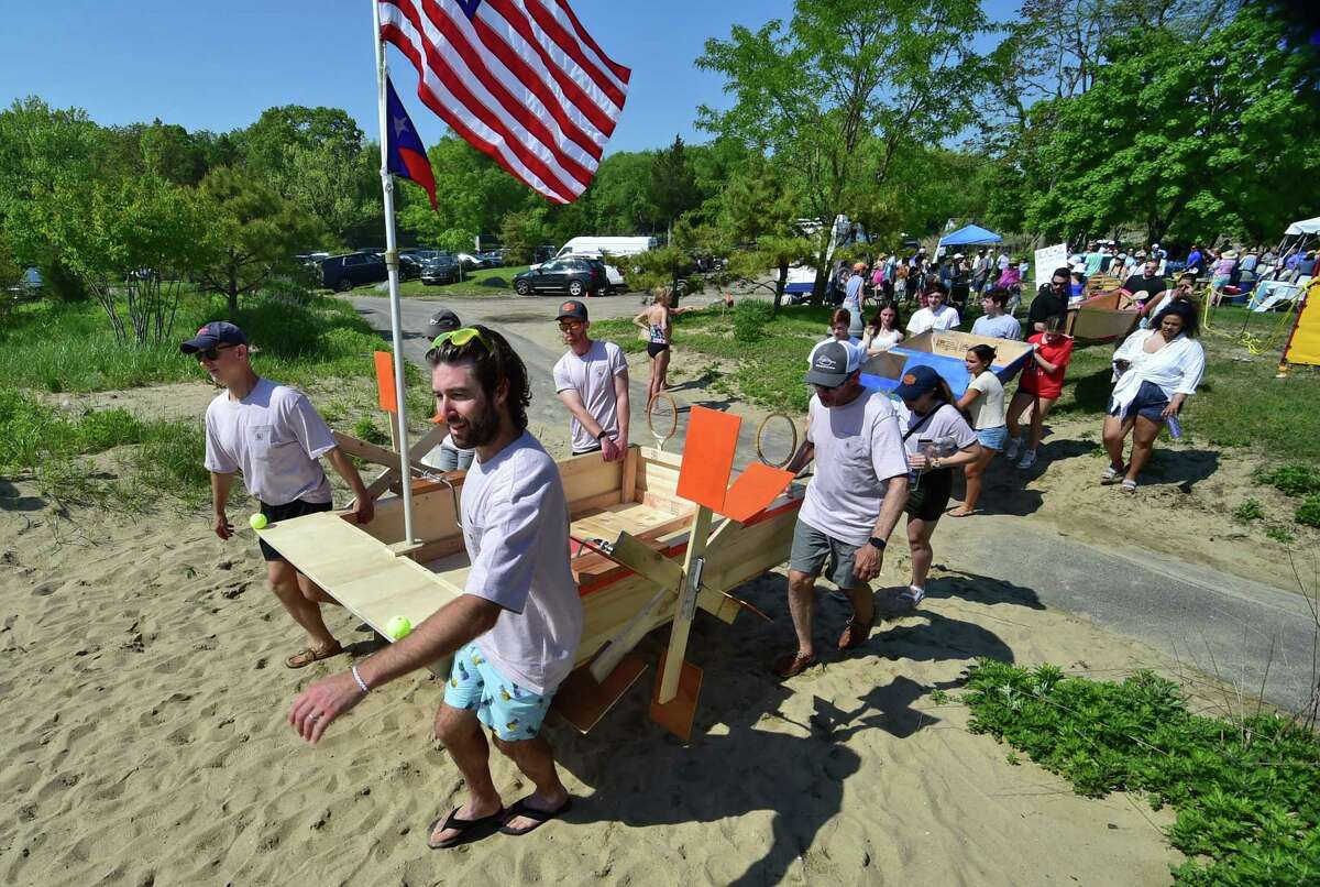 Teams in the "build your own boat" relay race compete during the 6th year of Showdown on the Sound at Weed Beach in Darien, Conn., on Saturday May 21, 2022. Showdown on the Sound is an annual fundraising event to honor life of Darien native, Michael Taylor, who died from opioid addiction.