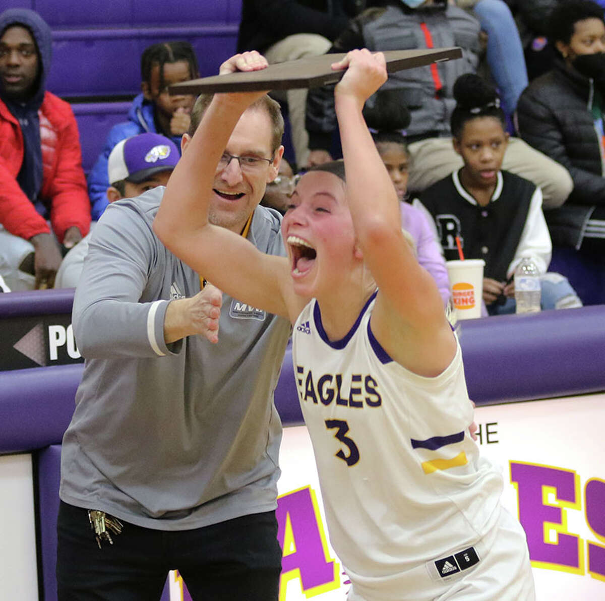 CM's Kelbie Zupan takes the championship plaque from CM AD Todd Hannaford and delivers it to teammates after the Eagles' won a regional title in Bethalto in February.