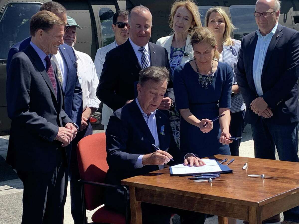 Gov. Ned Lamont signs a bill to keep Sikorsky's headquarters in Connecticut until 2042 Monday at the Sikorsky plant in Stratford.