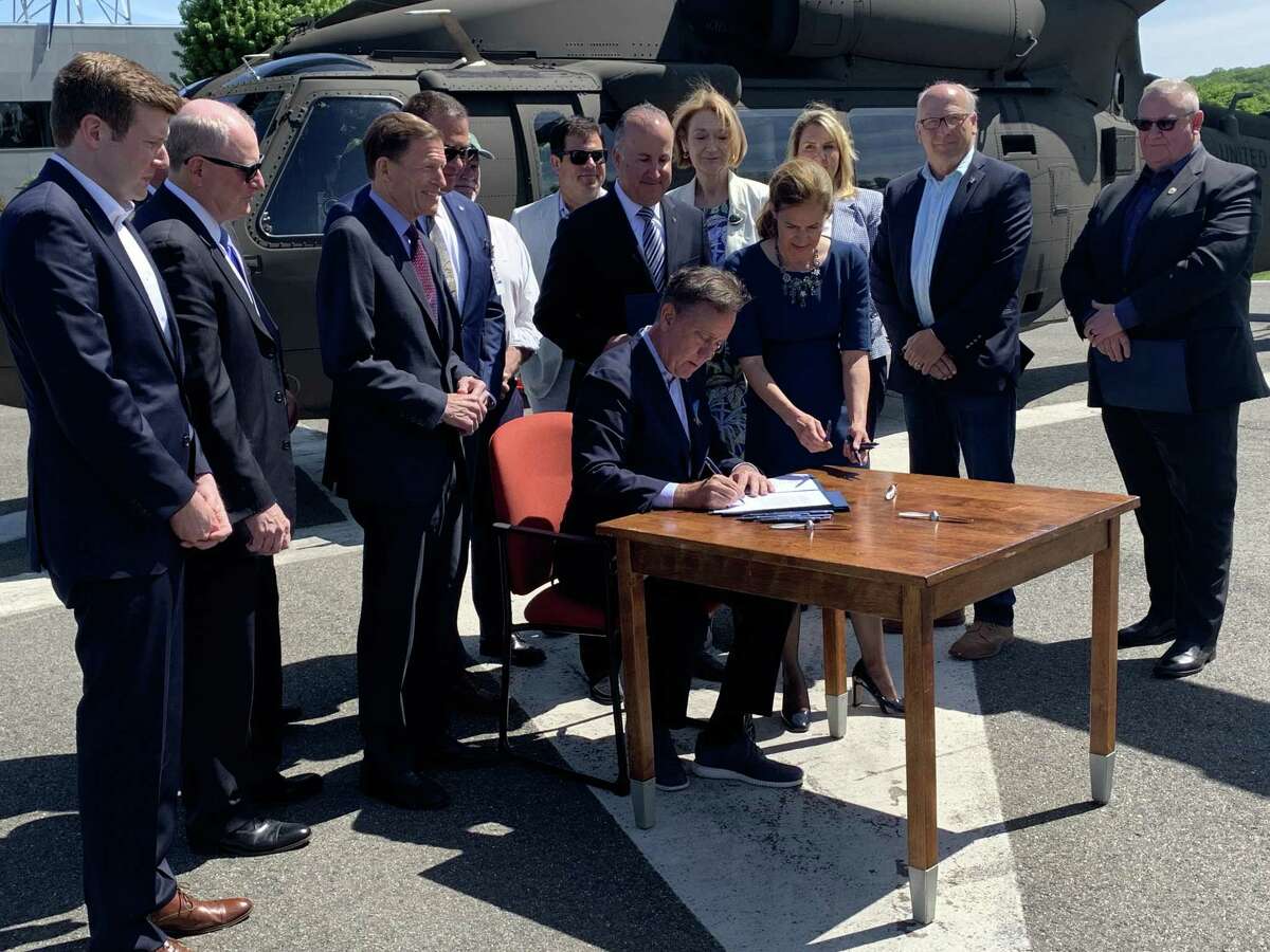 Gov. Ned Lamont signs a bill to keep Sikorsky's headquarters in Connecticut until 2042 Monday at the Sikorsky plant in Stratford.