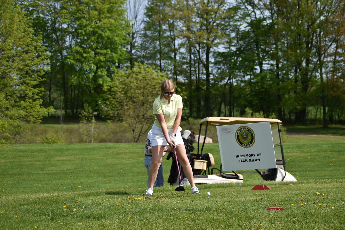 A participant in the Armed Forces Golf Tournament gets ready to swing behind a sign commemorating the memory of US Army member Jack Milan on Saturday, May 21, 2022.