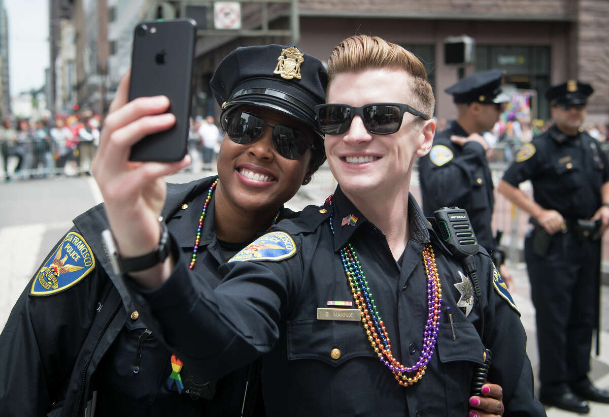 San Francisco police Officers Eureka Monroe, left, and Brenden Manix, right, take a selfie during the San Francisco Pride Parade in San Francisco on Sunday, June, 25, 2017. 