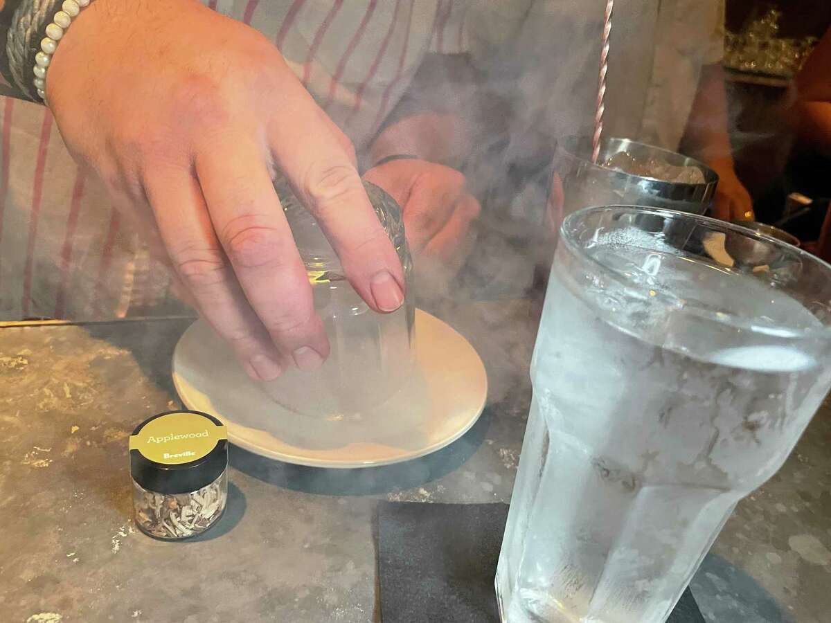 Bar manager David Naylor of The Modernist uses a smoke gun to create a smoked cocktail that incorporates gin and other flavors.