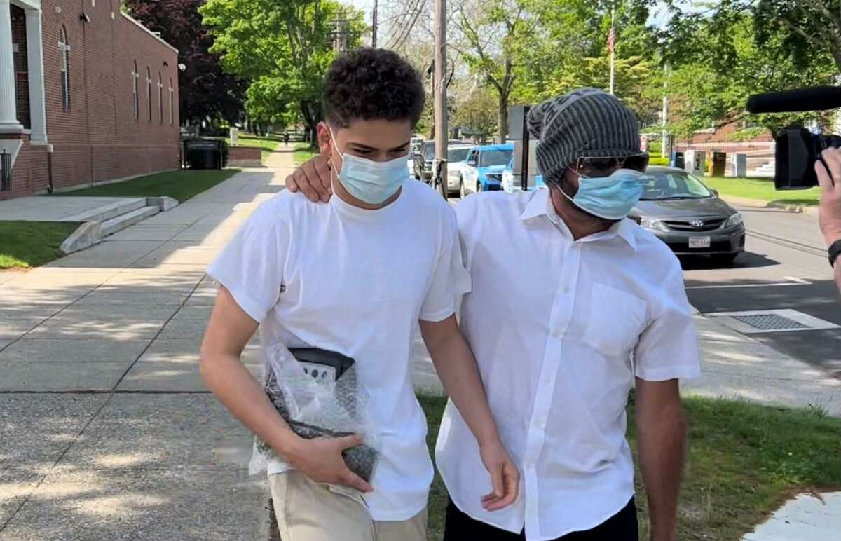 Raul Eliah Valle, left, walks out of Milford Superior Court after posting bond. Valle, 16, has been charged with murder in the stabbing death of 17-year-old James McGrath.