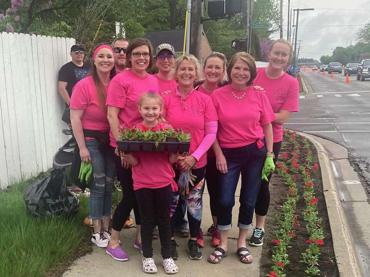 Midland residents help plant flowers along Eastman Avenue on May 21, 2022.