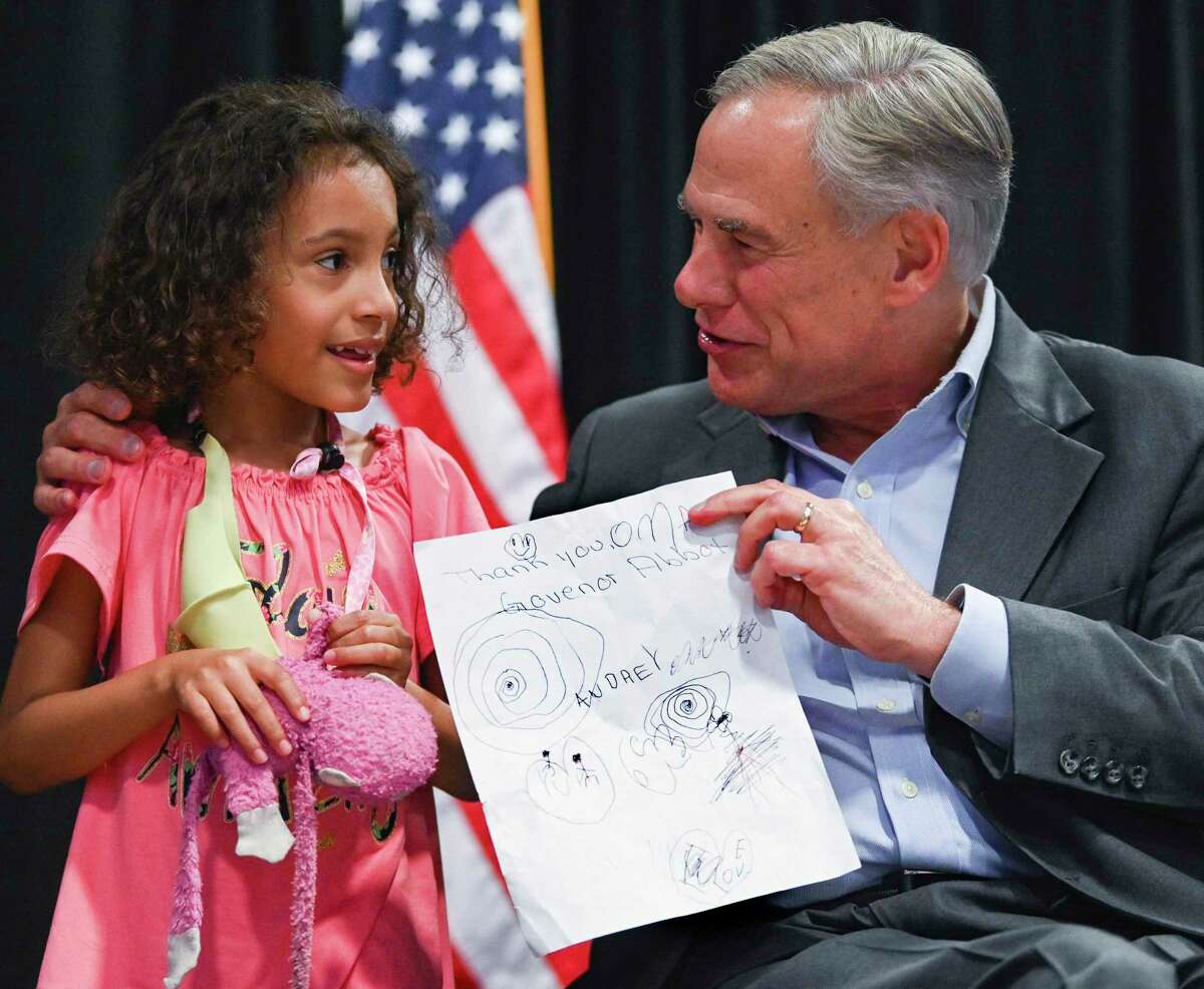 Texas Governor Greg Abbott speaks with Audrey Williams, 8, who gave him a hand-made thank you card at the PicaPica Plaza Event Center on the Southside of San Antonio on Monday, May 9, 2022.