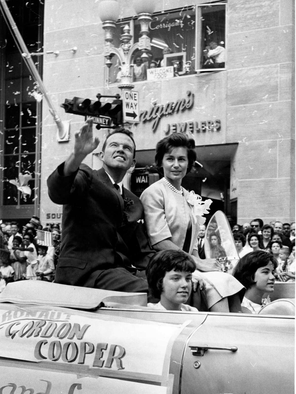 05/23/1963 - Astronaut L. Gordon Cooper waves to the crowd lining the streets of downtown Houston. Cooper rides with his wife, Trudy, and two daughters in the ticker-tape parade held in his honor following his completion of the sixth Mercury manned spaceflight. On May 15-16, 1963, he circled the Earth 22 times in the space capsule Faith 7.
