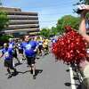 Special Olympics athlete Aaron Drescher, left, and Police Cpl. John Mrozek carry the Flame of Hope to the 2022 Special Olympics USA Games Law Enforcement Torch Run rally outside the WWE headquarters in Stamford Monday.