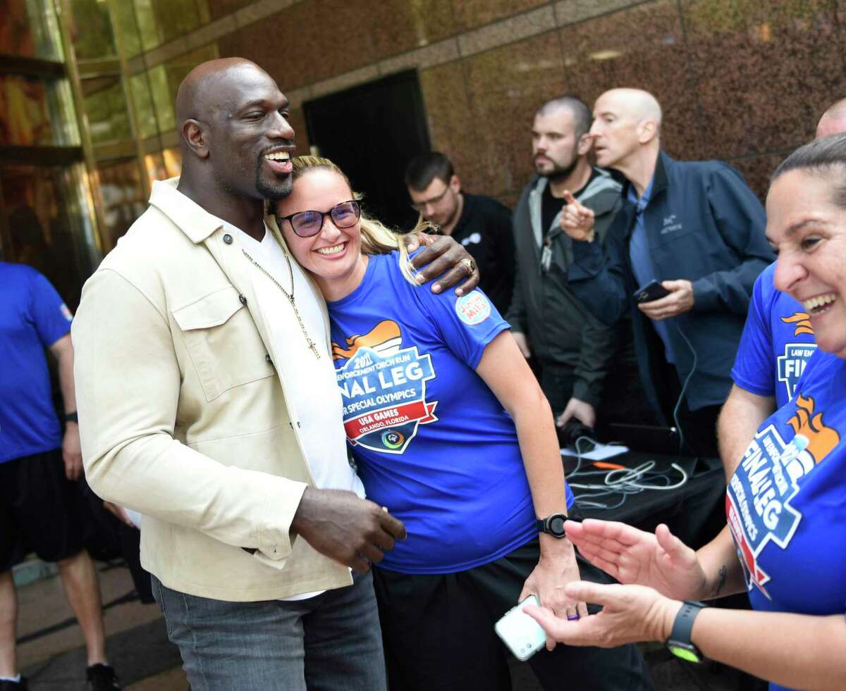 WWE wrestler Titus O'Neil mets a fan, Samantha Phillips, at the 2022 Special Olympics USA Games Law Enforcement Torch Run rally outside the WWE headquarters in Stamford Monday.