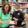 REAL Cookies co-founder Maria Felton, left, looks at food nutrition labels with Julian Curtiss fifth-graders Malia Flash, center, and Johana Diaz at Whole Foods in Greenwich, Conn. Tuesday, May 18, 2022. The Get Real Foods owners introduced the “REAL Food is Fuel” pilot program to educate elementary students on how to read nutrition labels and the importance of making healthy food choices. After a lesson at school, students took a field trip to Whole Foods to browse items and put what they learned to the test.