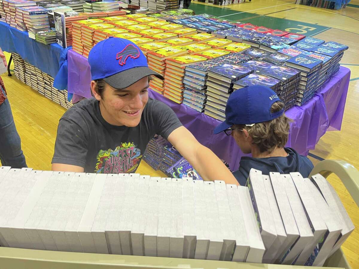 Aiden O'Hara and his brother Riley are helping store some of the 40,000 free books that were given away Saturday, May 21 at The Carousel of Reading event at Norwalk High School.  Aiden volunteered because he always enjoyed helping his mother organize the book fair at All Saints Catholic School growing up.