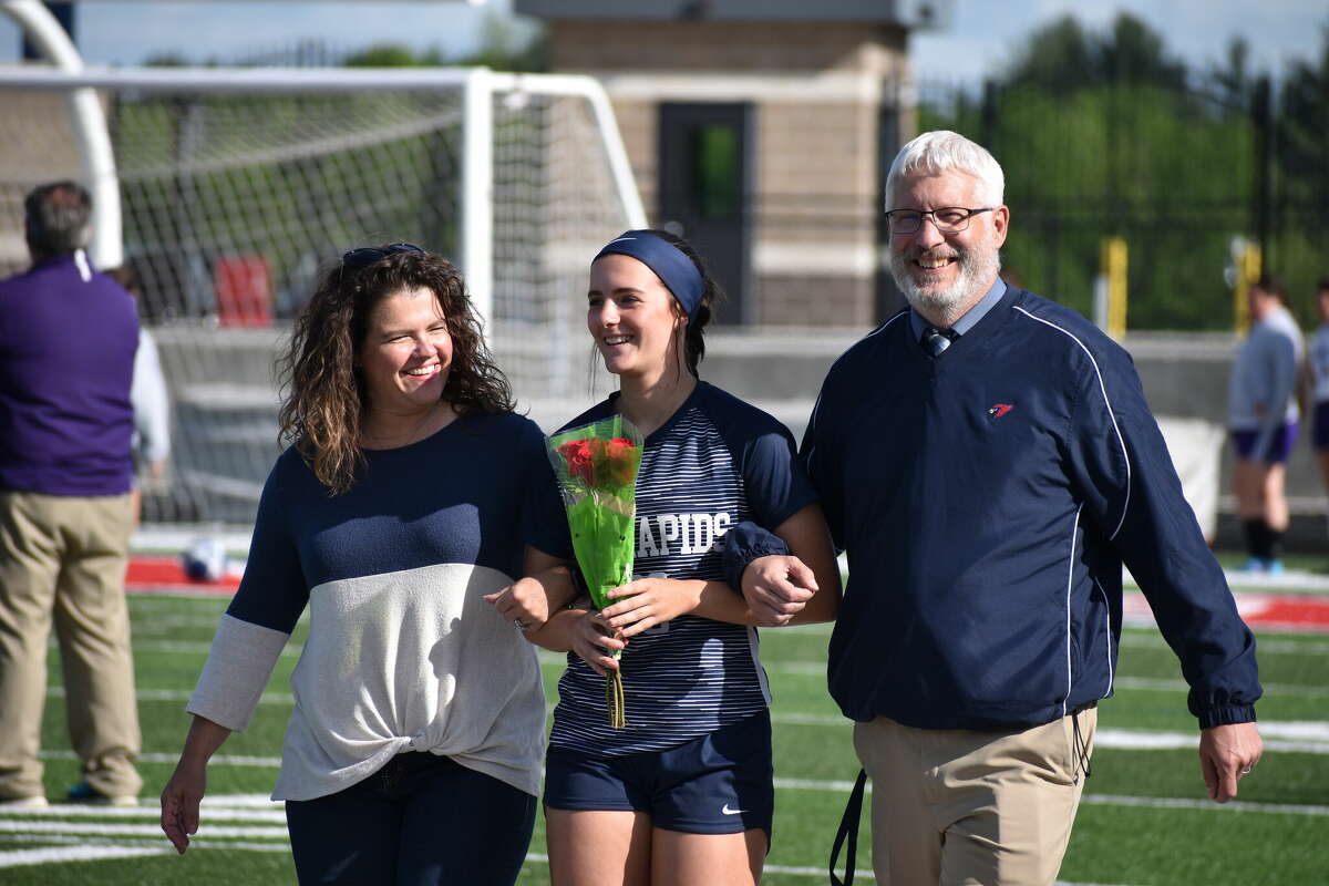 Maddie Pincumbe walks with her parents on Senior night. Pincumbe would have four shots and three shots on goal in the win.