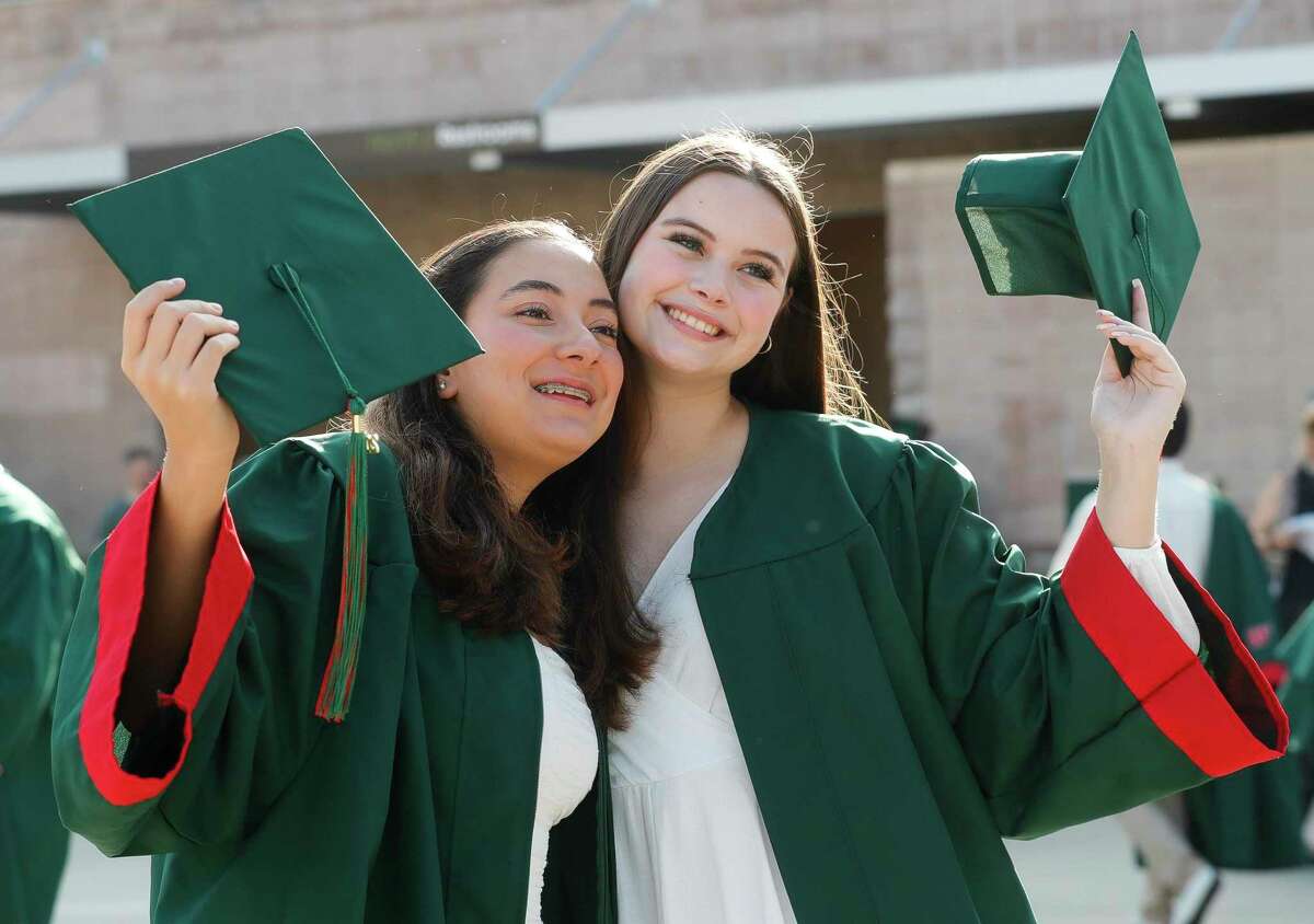 The Woodlands High School seniors Isabel Bonilla and Vivian Roberts pose for a photo before a graduation ceremony at Cynthia Woods Mitchell Pavilion, Monday, May 23, 2022, in The Woodlands.