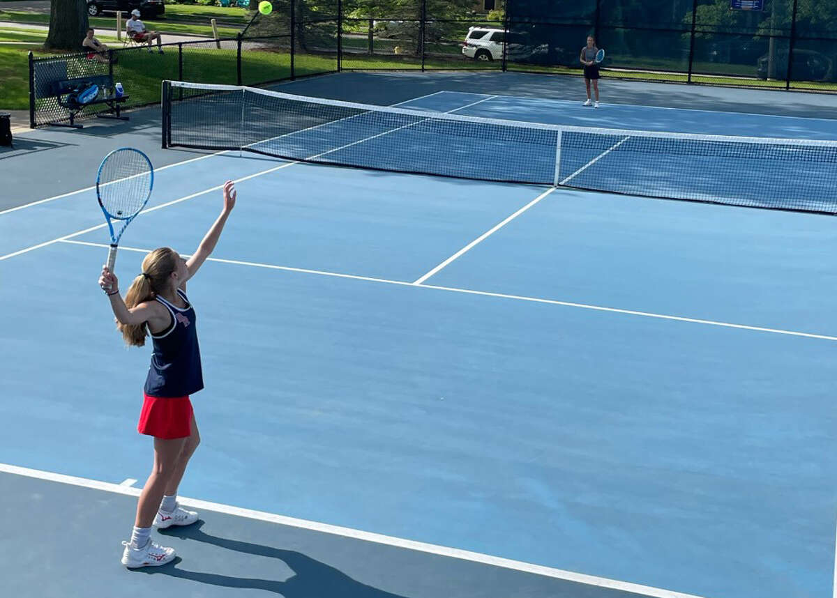 Brenna Mossel attempts a serve in her first years playing tennis for the Cardinals.