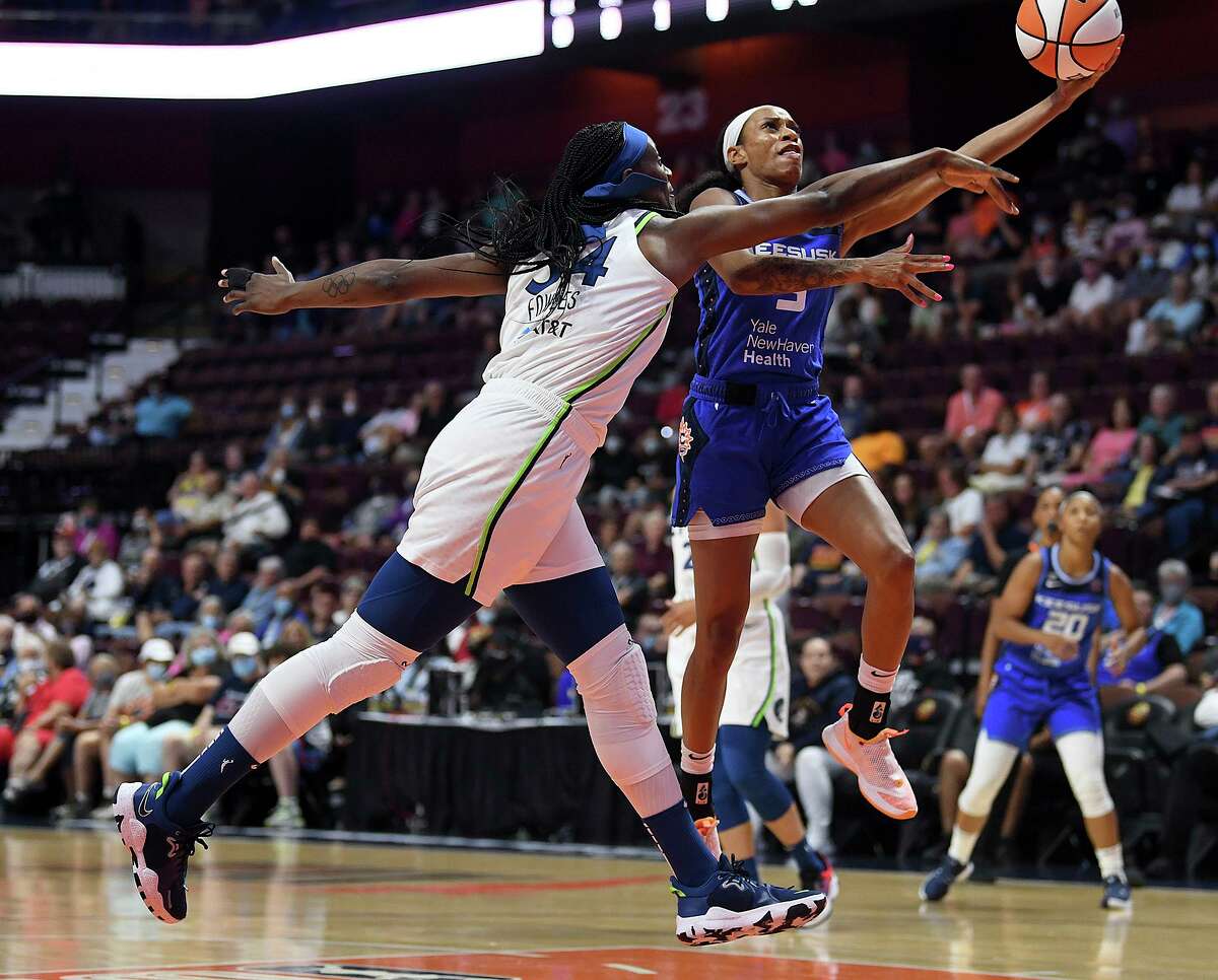 Connecticut Sun’s Jasmine Thomas puts up a basket over the Minnesota Lynx’s Sylvia Fowles during a game in 2021.