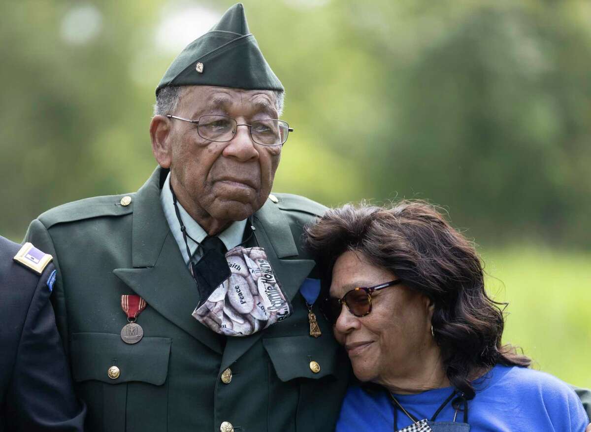 Eva Hollins rests her head on her husbands chest, Pfc. Romie Hollins during the 4th Annual Memorial Day Celebration at the Sweet Rest Cemetery, Monday, May 31, 2021, in Tamina. Tamina’s Memorial Day ceremony and fundraiser on Monday will focus on raising funds to build a new home for the Hollins.