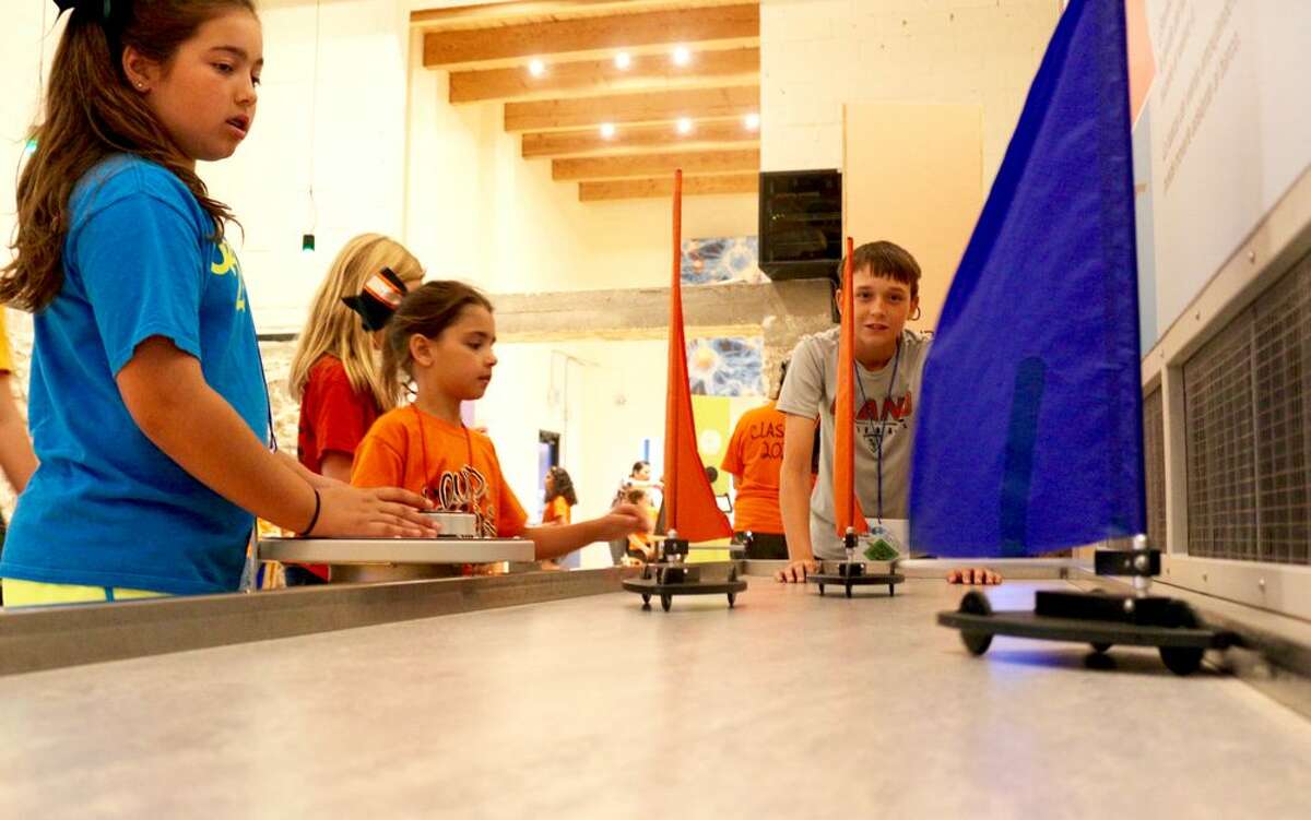 Kids experiment with wind and air pressure at the Science Mill's sailboat table on June 15, 2017.