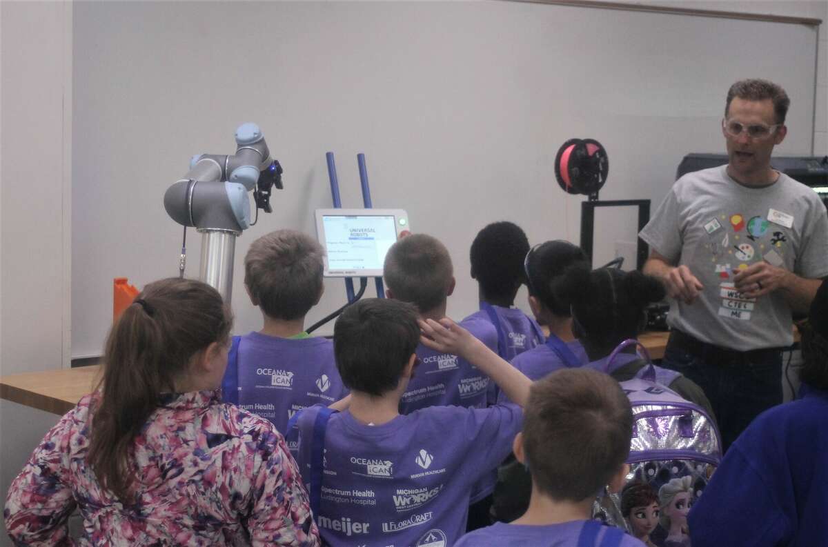 Jesse Moser, paraprofessional for the West Shore Educational Service District Career and Technical Education program, shows students a robotic arm Tuesday in the West Shore Community College mechatronics lab.