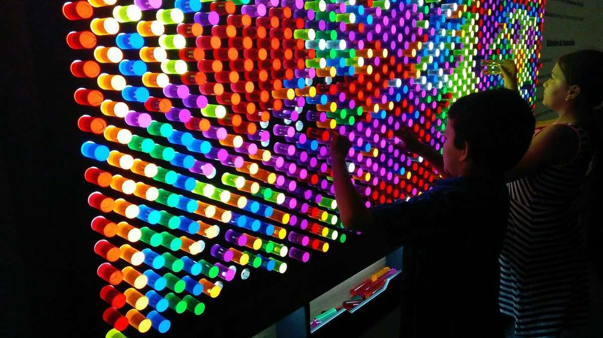 Two kids create an art display with colored lights at McNay Art Museum in San Antonio, TX on June 10, 2018.