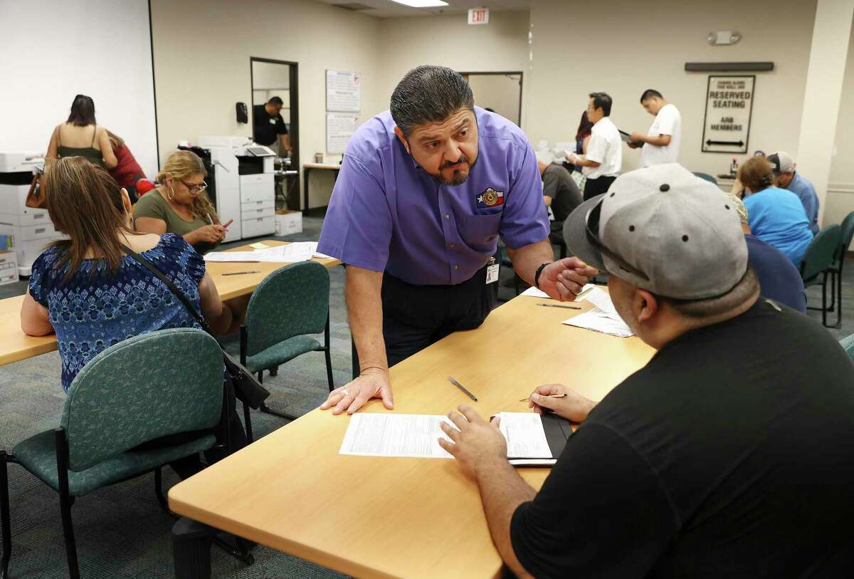 Chief Appraiser Michael Amezquita (center) helps a property owner with protest forms as a steady flow of people pay a visit to the Bexar Appraisal District office as the deadline to protest property taxes looms on Monday, May 16. The appraisal district on Tuesday reported a record number of more than 155,000 protests that have been filed on 2022 appraisals.
