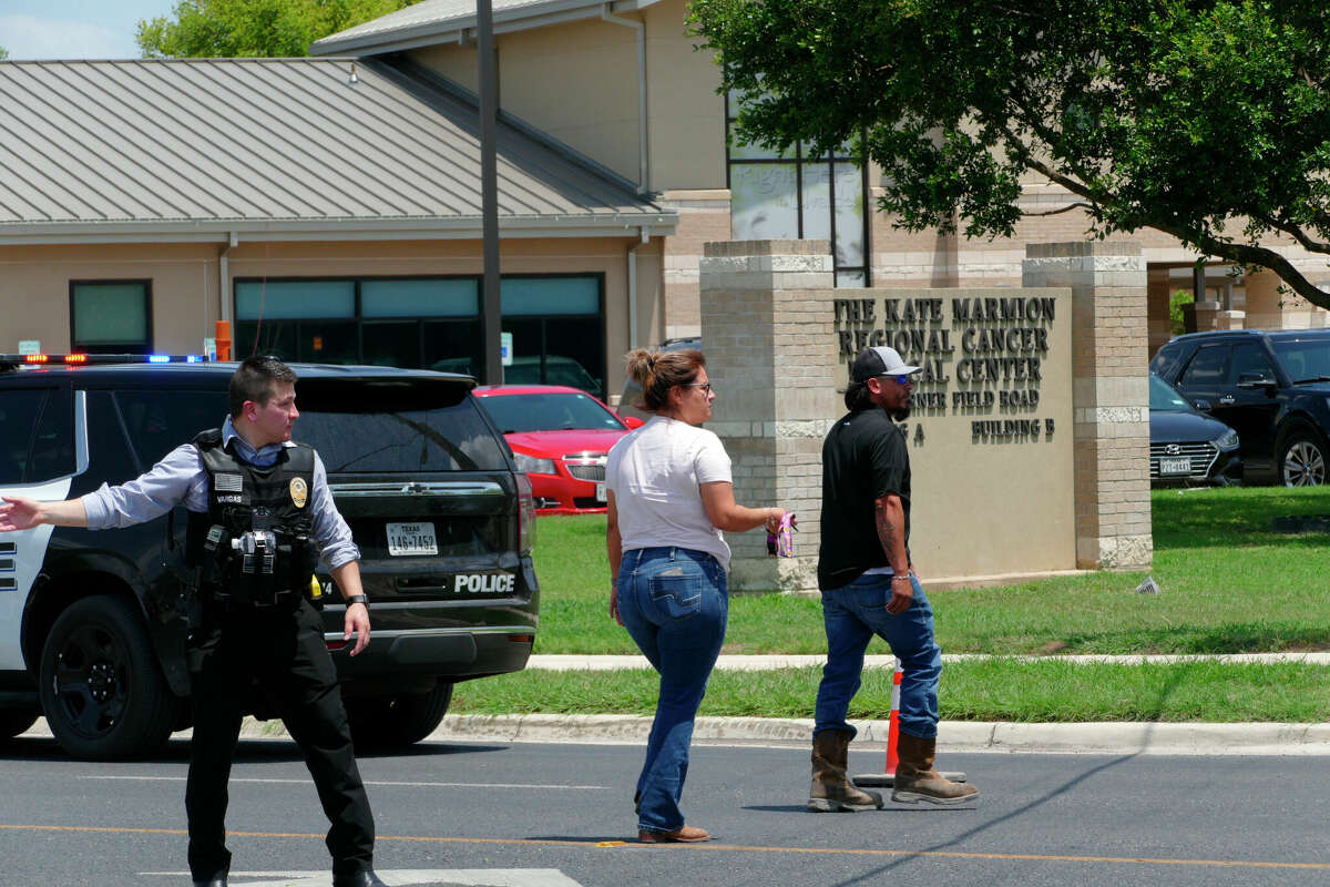 A law enforcement officer helps people cross the street at Uvalde Memorial Hospital after a shooting was reported earlier in the day at Robb Elementary School, Tuesday, May 24, 2022, in Uvalde, Texas. (Billy Calzada/The San Antonio Express-News via AP)