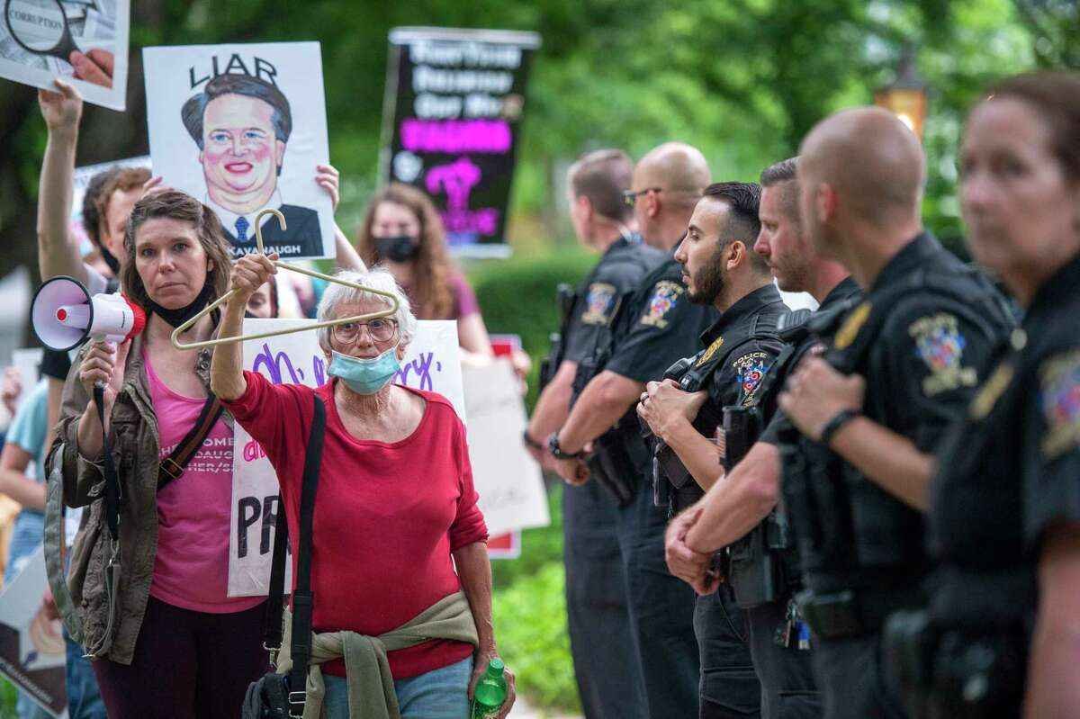 CHEVY CHASE, MD - MAY 18: Police officers look on as abortion-rights advocates hold a demonstration outside the home of U.S. Supreme Court Justice Brett Kavanaugh on May 18, 2022 in Chevy Chase, Maryland. Protests have been organized intermittently outside the homes of justices who signed onto a draft opinion that would overturn the landmark Roe v Wade decision, which made abortion legal across the U.S. in 1973. (Photo by Bonnie Cash/Getty Images)