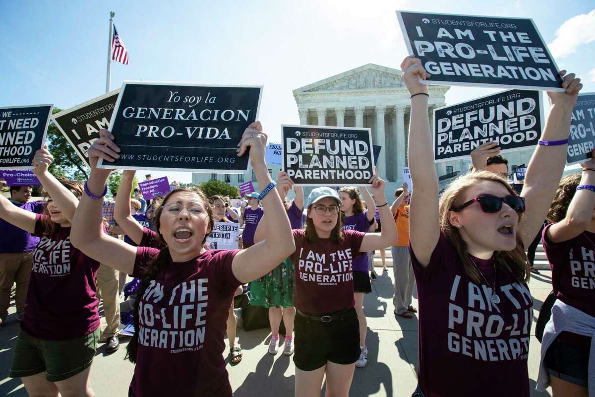 FILE - In this June 25, 2018 file photo, pro-life and anti-abortion advocates demonstrate in front of the Supreme Court in Washington. Republican lawmakers in at least a half dozen GOP-controlled states already are talking about copying a Texas law that bans abortions after a fetal heartbeat is detected. The law was written in a way that was intended to avoid running afoul of federal law by allowing enforcement by private citizens, not government officials. (AP Photo/J. Scott Applewhite, File)